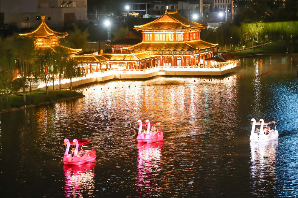9月13日，游客在兰州市雁滩公园内的湖面上乘船夜游。新华社记者　郎兵兵　摄