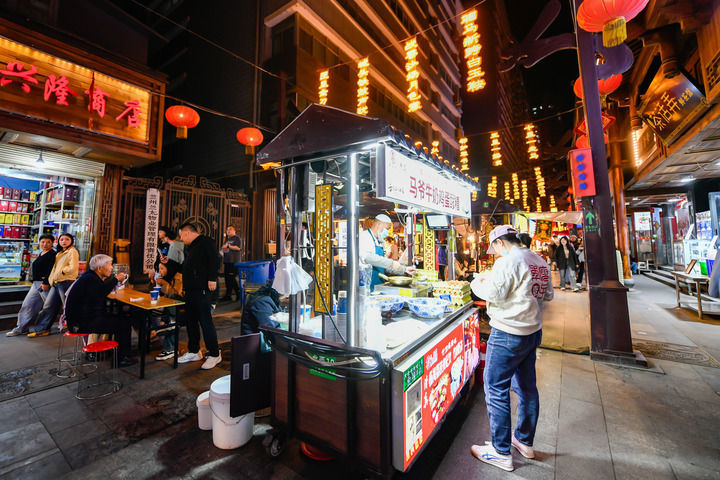 4月28日，游客在兰州市城关区大众巷新光夜市购买特色美食牛奶鸡蛋醪糟。新华每日电讯记者　郎兵兵　摄