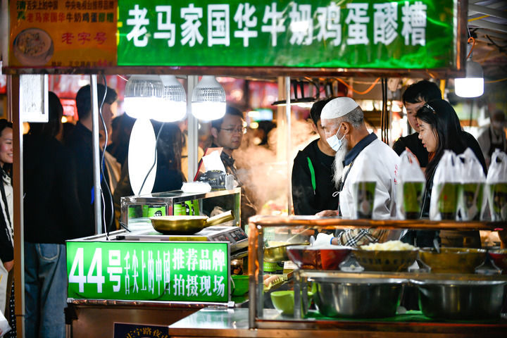4月28日，游客在兰州市城关区正宁路小吃夜市选购特色美食。新华每日电讯记者　郎兵兵　摄