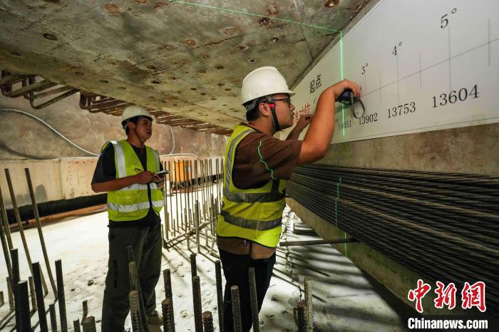 9月26日凌晨，九江快速路跨庐山站转体斜拉桥在进行转体施工。图为技术人员对转动角度进行复测。沈嘉鹏 摄
