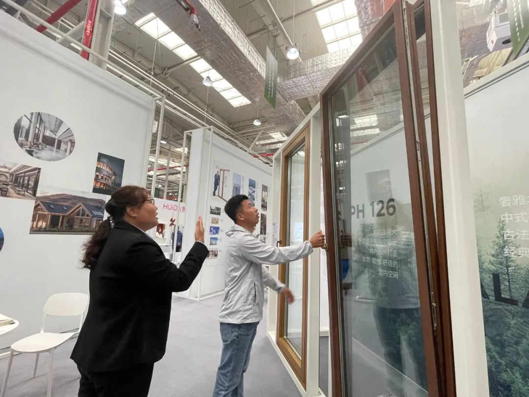 图1：在高碑店顺达墨瑟门窗有限公司展位，工作人员为观展市民讲解门窗性能。