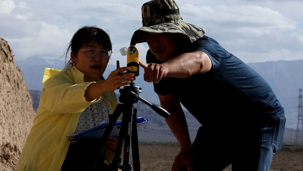 8月16日，嘉峪关丝路（长城）文化研究院长城保护研究所所长张斌（右）和同事在嘉峪关长城第二墩附近使用风速仪监测风速。新华社记者　张智敏　摄