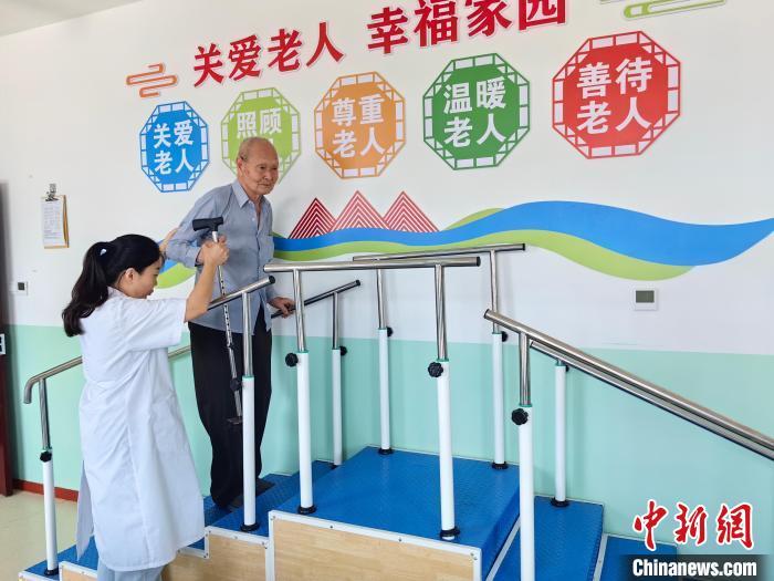 9月25日，深州市救坤堂养老中心，老人在医护人员搀扶下进行锻炼。王鹏 摄