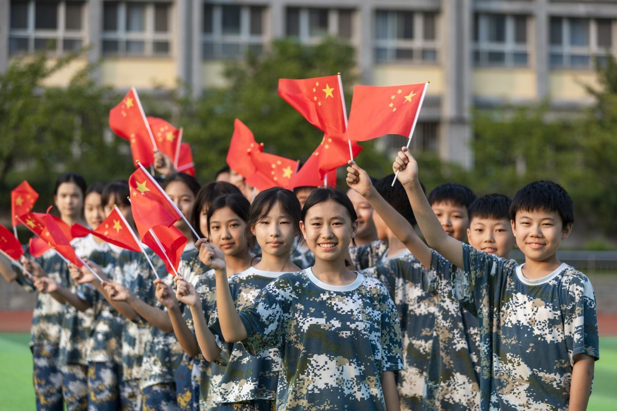 9月27日，日照港中学，同学们挥舞着五星红旗，脸上洋溢着笑容。单英 摄