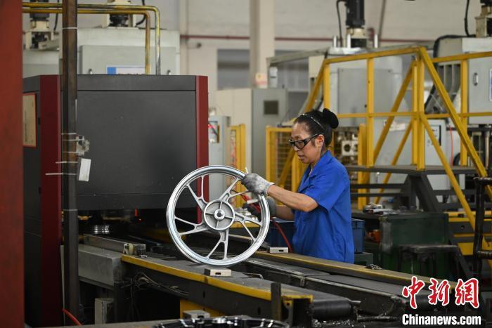 资料图为2024年9月，重庆垫江的一家摩托车轮毂生产基地内，工人正在检测产品。张旭 摄