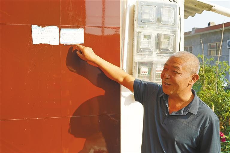 9月30日，铜川市印台区红土镇孙家砭村水管员孙志明向记者介绍“印台区农村安全饮水服务连心卡”。