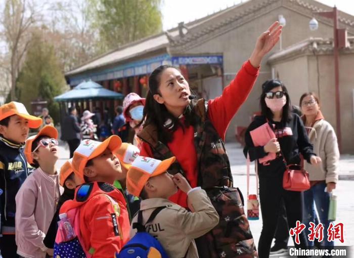 图为张晓燕(右三)向游客讲解长城历史(资料图)受访者供图