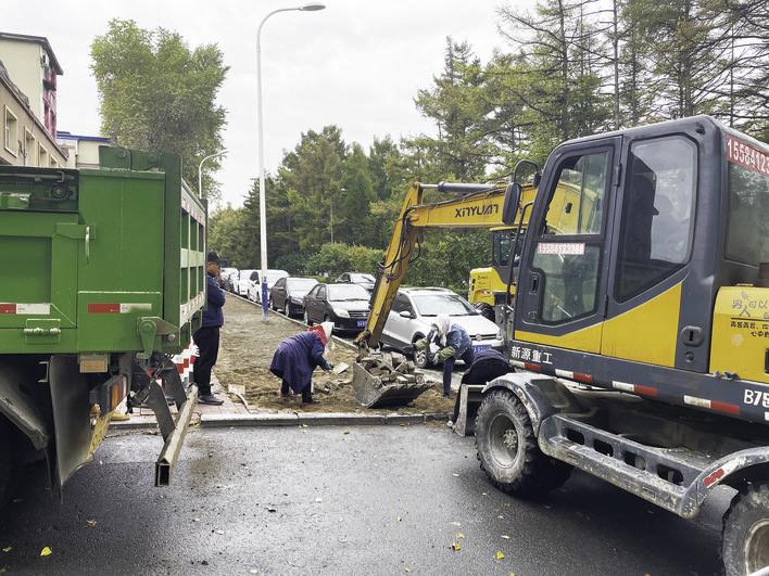 国庆假期，南湖新村中街，工作人员坚守岗位，铺设人行步道。 赵滨 摄