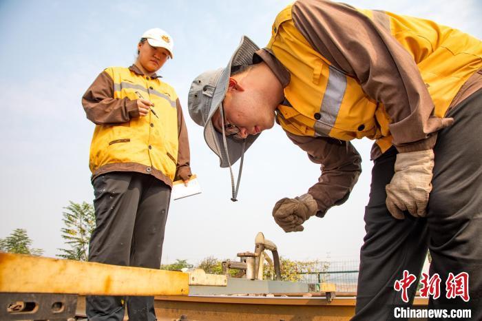 图为铁路职工对作业地段精准测量以确保行车安全。王宽宁磊 摄