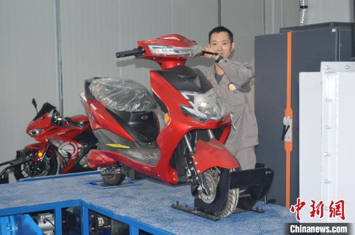 资料图为工作人员在对摩托车成品进行调试检测，准备出厂。重庆市宏立摩托车制造有限公司供图