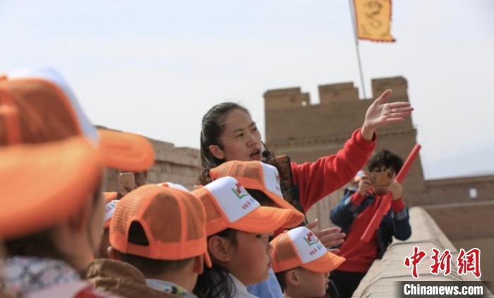 图为张晓燕(右二)在嘉峪关关城上为小朋友们进行讲解(资料图)受访者供图