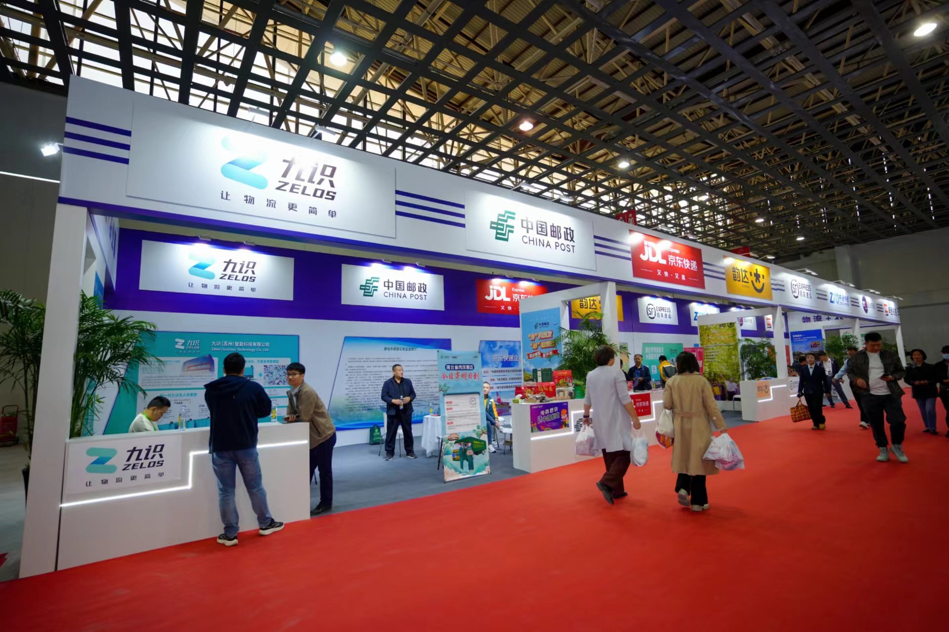 （图为物流+农业展现场，工作人员为前来咨询的客商进行业务解答）