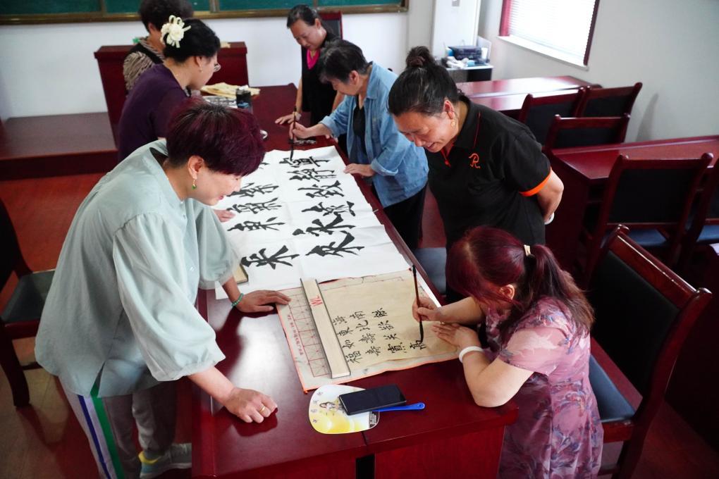 5月16日，在山东省潍坊市潍城区月河社区的老年大学教学点，学员们学习书法。新华社记者 徐速绘摄