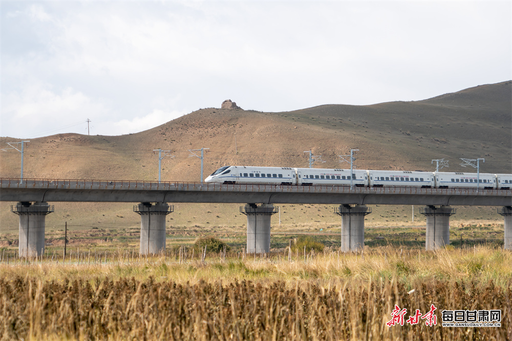 10月12日，在兰张高铁兰武段，列车从武威天祝县明代烽燧旁驶过。