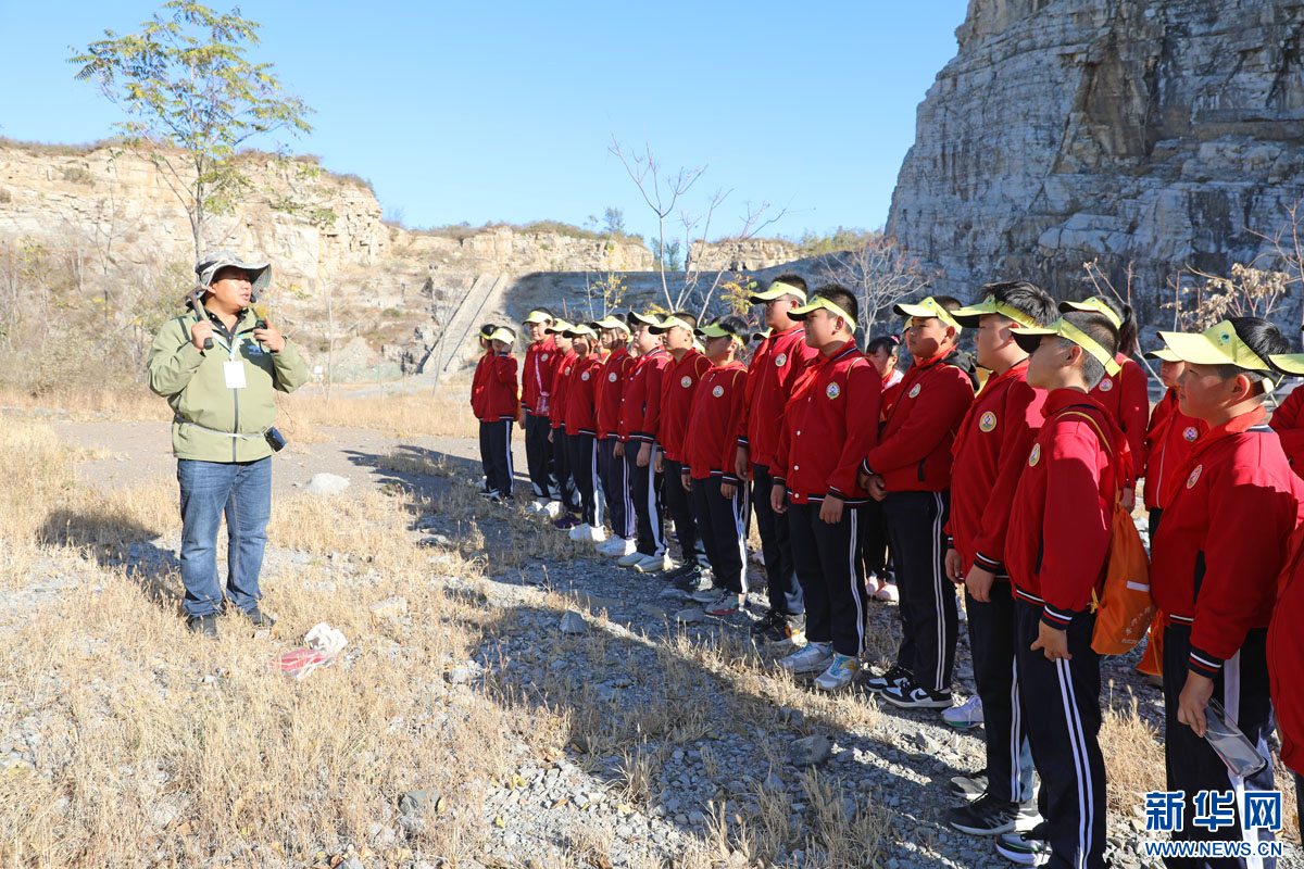 学生们在柳江盆地保护区亮甲山区域聆听专家讲解保护区的特点以及地质考察相关知识。新华网 魏会博 摄