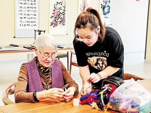 9月18日，秦皇燕达金色年华健康养护中心的工作人员陪伴入住老人做丝网花。