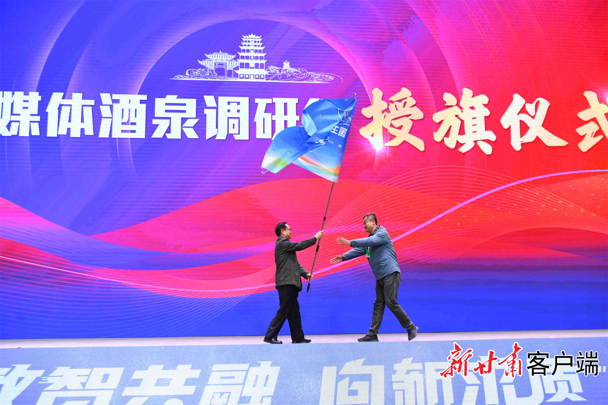 中国报业协会副理事长、光明日报社原秘书长马振华为参加全国主流媒体酒泉行采访活动记者代表授旗