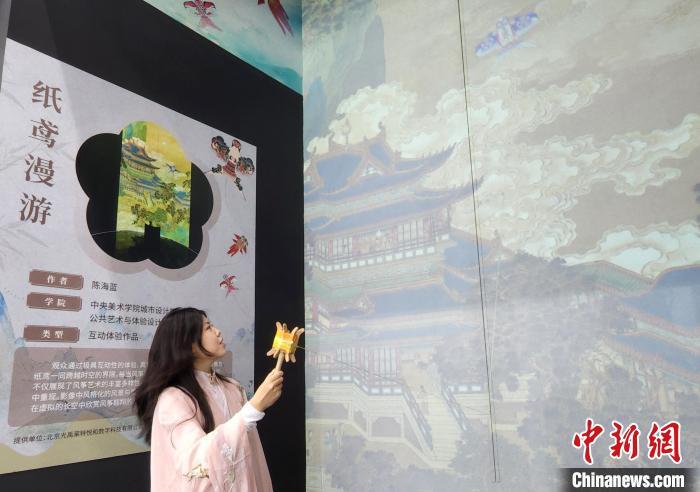 图为观众身穿汉服,体验在虚拟世界里放纸鸢。中新社记者 赵晓 摄