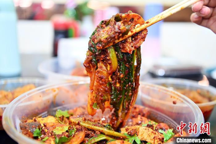 3月14日，甘肃省天水市秦州区，食客展示裹满红油辣子的麻辣烫。九美旦增　摄