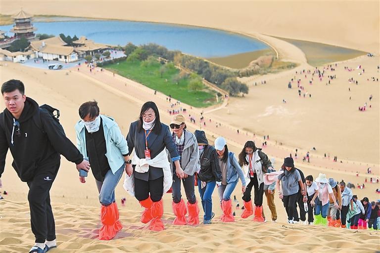 采访团在鸣沙山、月牙泉实地走访，了解旅游发展情况。