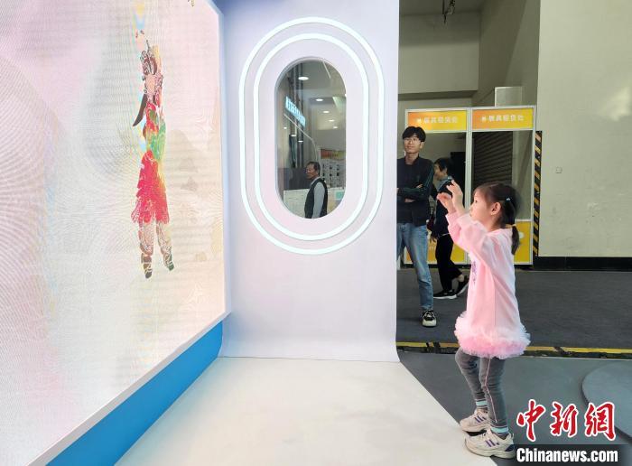 图为小观众置身皮影体感互动空间,模仿皮影动作。中新社记者 赵晓 摄