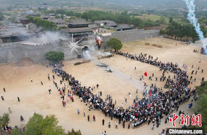 2024年10月13日，在山东省临沂市沂南县马牧池乡红嫂家乡旅游区，游客在参与情景剧《跟着团长打县城》演出。(无人机照片)沂南县委宣传部 供图