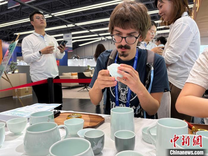 10月19日,在2024中国景德镇国际陶瓷博览会现场,一位客商正在体验给瓷器“找茬”。中新社记者 李韵涵 摄