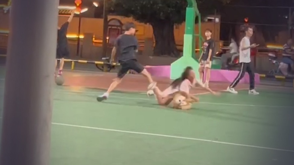 男孩在篮球场内突然跳起飞脚从背后踹倒女孩，警方已介入处理