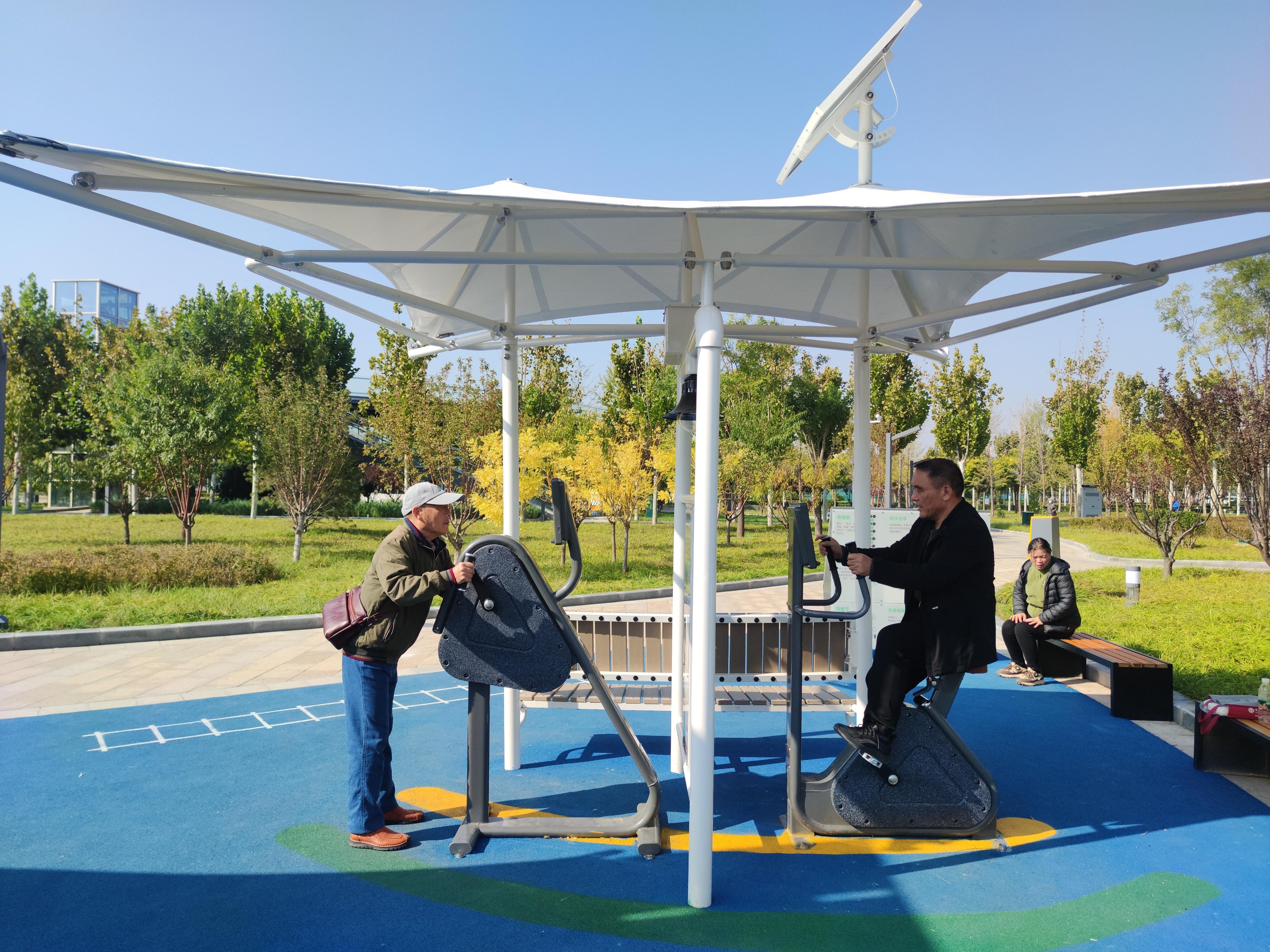 市民在中央绿色体育公园内的室外智能健身房锻炼