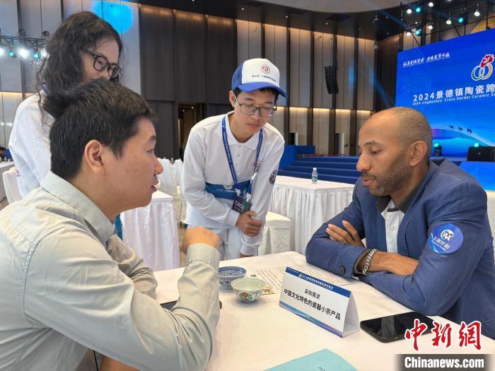 10月19日,在2024中国景德镇国际陶瓷博览会现场,瓷器采购商正在与景德镇陶瓷企业洽谈。中新社记者 李韵涵 摄