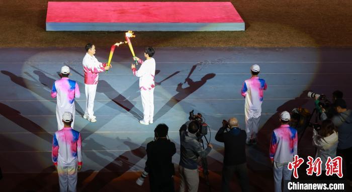 图为在江西省九江市第十四届运动会开幕式现场，火炬手点燃火炬。　吴军 摄