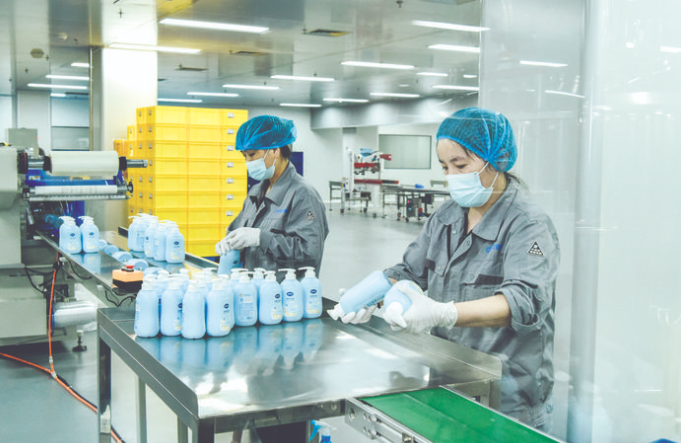 工作人员检查洗护用品包装瓶上的生产日期等信息。