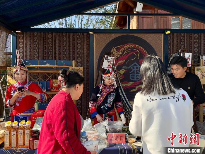 圖為黃予心(中)在江西吉安金坪民族鄉八寨集市售賣畬族特產。中新網記者劉子衿 攝