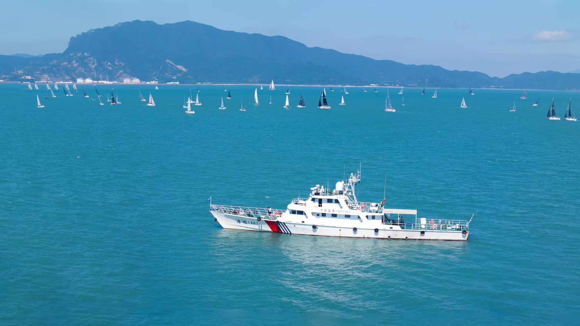 （图片描述：比赛首日，大亚湾海事局派出海巡1462与现场执法人员对赛事水域进行警戒护航）
