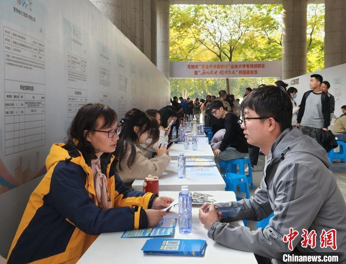 学生们在现场与企业招聘人员交流。赵晓 摄