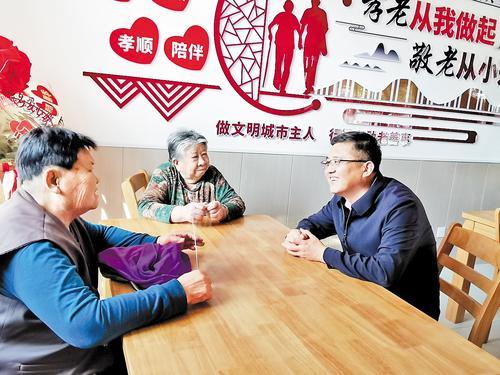 丹青（右一）在敬老食堂与老人谈心。