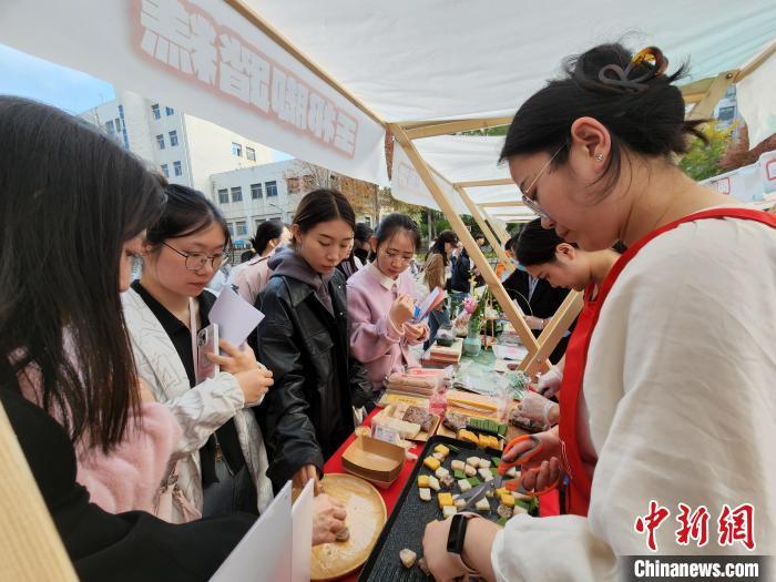 现场煎烤的玉祁脚踏糕吸引学生们品尝。赵晓 摄