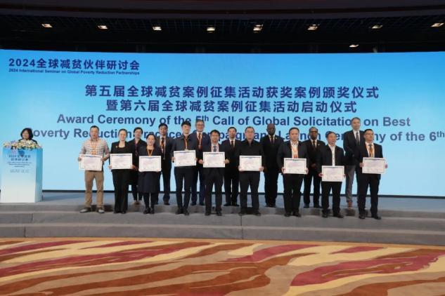 图为上台领取“第五届全球减贫最佳案例”获奖证书的单位