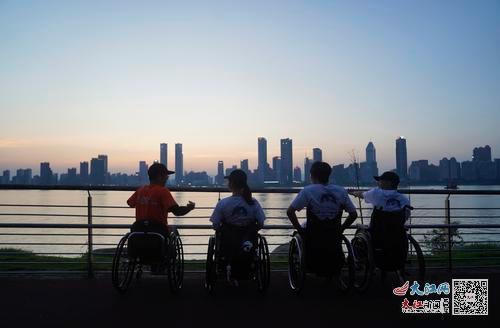 夕阳下，谢俊武和乐跑团的团友们交流。