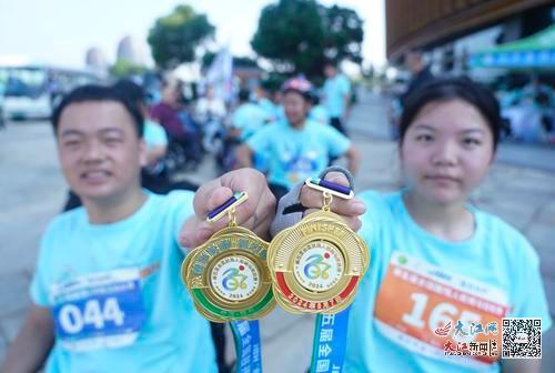 第五届全国肢残人轮椅马拉松赛，新加入的团友志刚和子怡展示自己的奖牌。