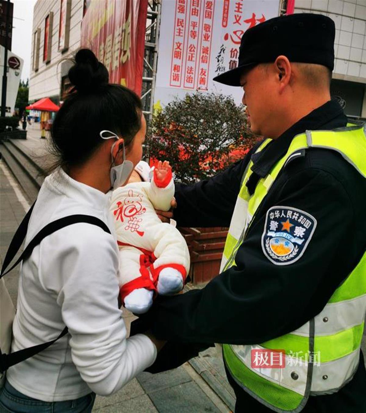 图为执勤辅警将孩子还给宝妈（围观群众拍摄）.jpg