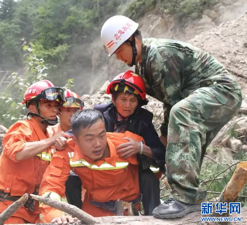 图为杨玺在2017年8月九寨沟地震救援现场背起被困群众（受访者供图）