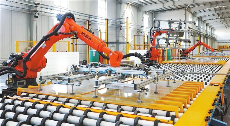 甘肃凯盛大明光能科技有限公司生产线上,智能机械臂正在进行生产。