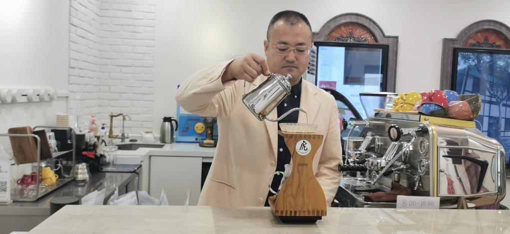 11月9日，“虎咖啡”老板朱小虎用产自危地马拉的咖啡豆制作手冲咖啡。新华社记者任军 摄