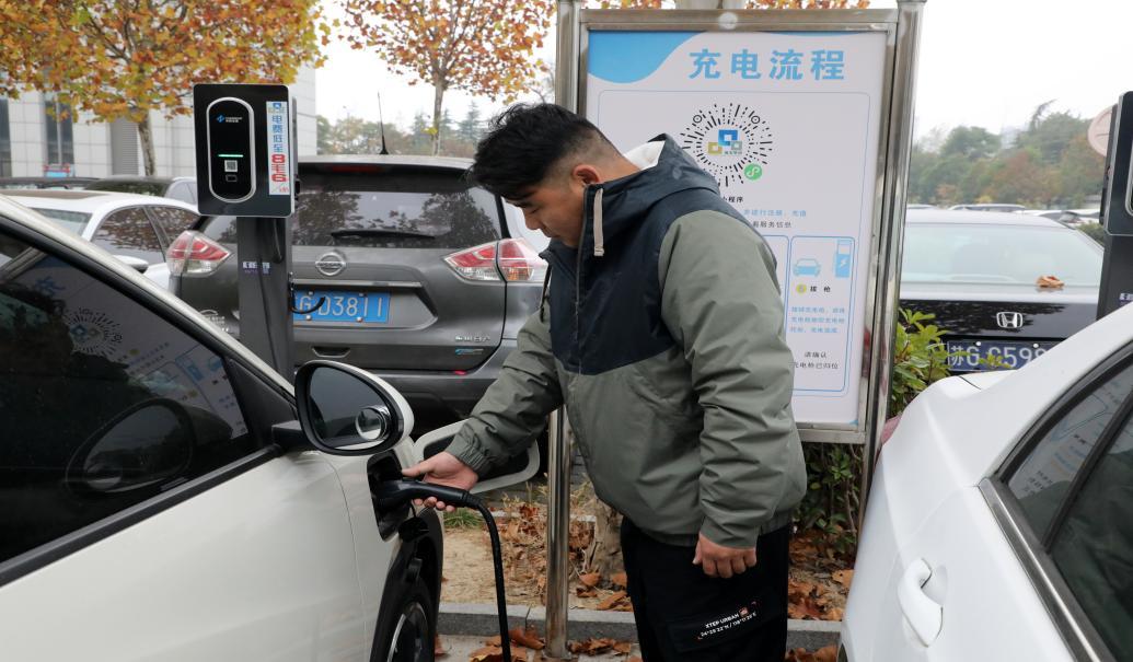 （图为市民在充电站为车辆充电）