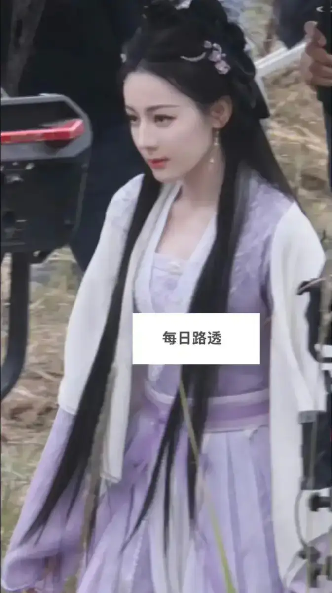 迪丽热巴当天身穿一袭紫衣，两缕秀发搭在身前。