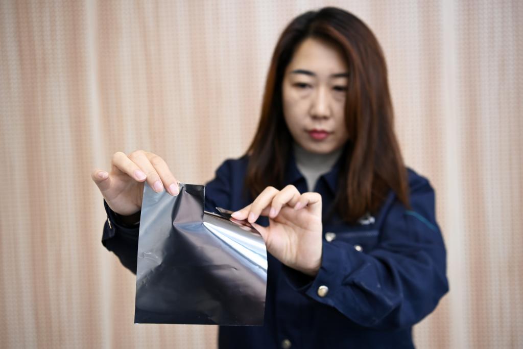 10月15日，在甘肃甬金金属科技有限公司，工作人员展示手撕钢产品。新华社记者　范培珅　摄