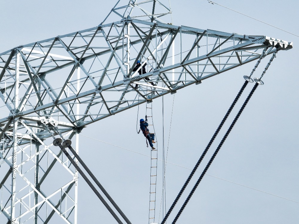 ▲施工人员正在哈密-重庆±800千伏特高压直流输电线路工程导线展放现场,开展塔上作业。通讯员 林熙熙 摄