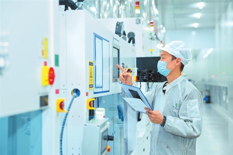 工作人员在酒泉正泰新能源科技有限公司高效晶硅电池生产无尘车间查看生产情况