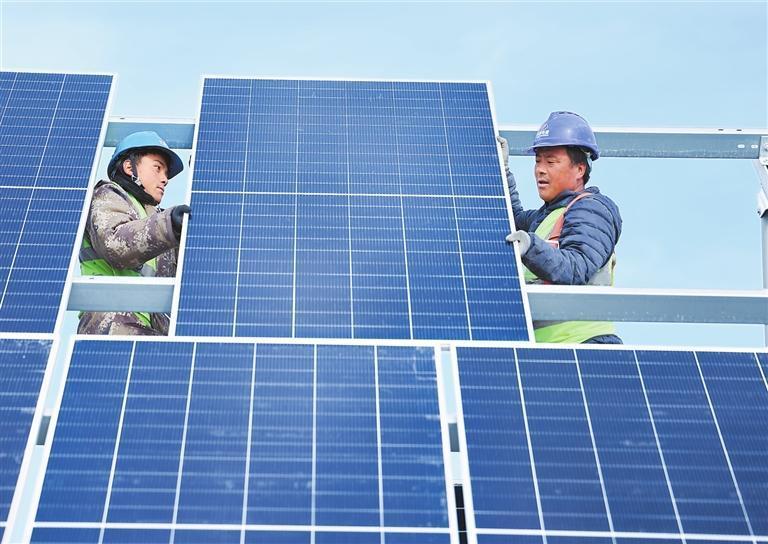 酒泉市金塔中光太阳能“10万千瓦光热+60万千瓦光伏”项目建设现场,施工人员正在安装光伏板。
